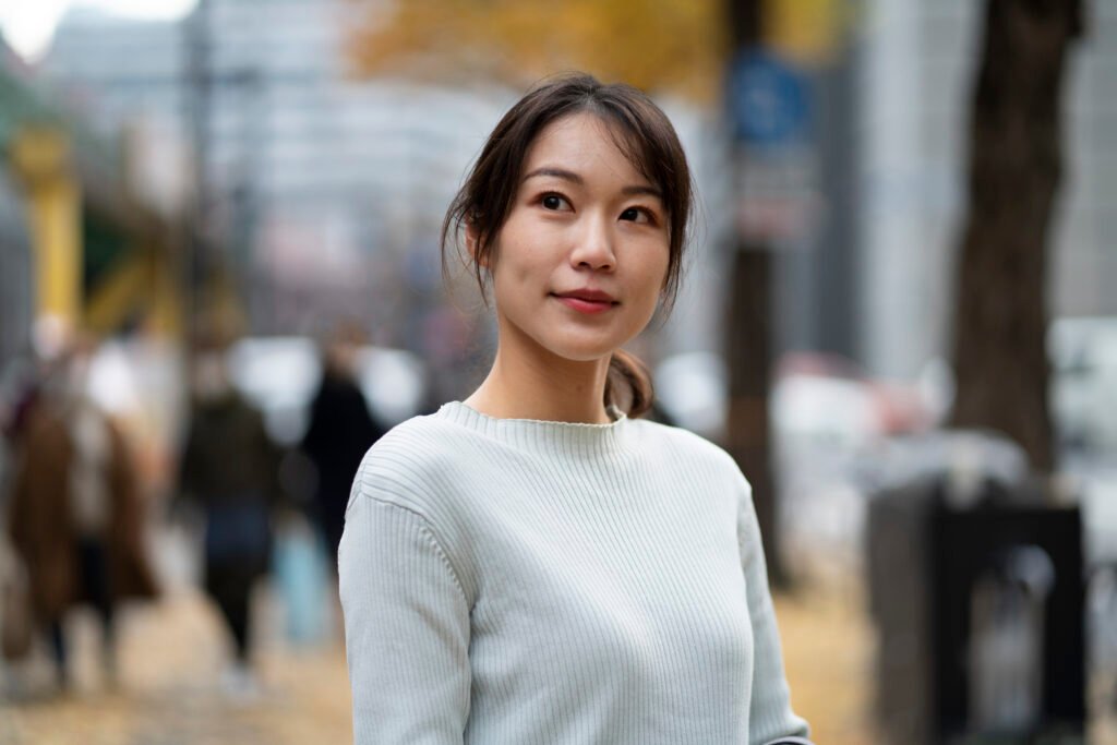 mulher sul coreana leve sorriso cabelos lisos castanhos presos blusinha branca Korean cosmetics K‑beauty cosméticos coreanos