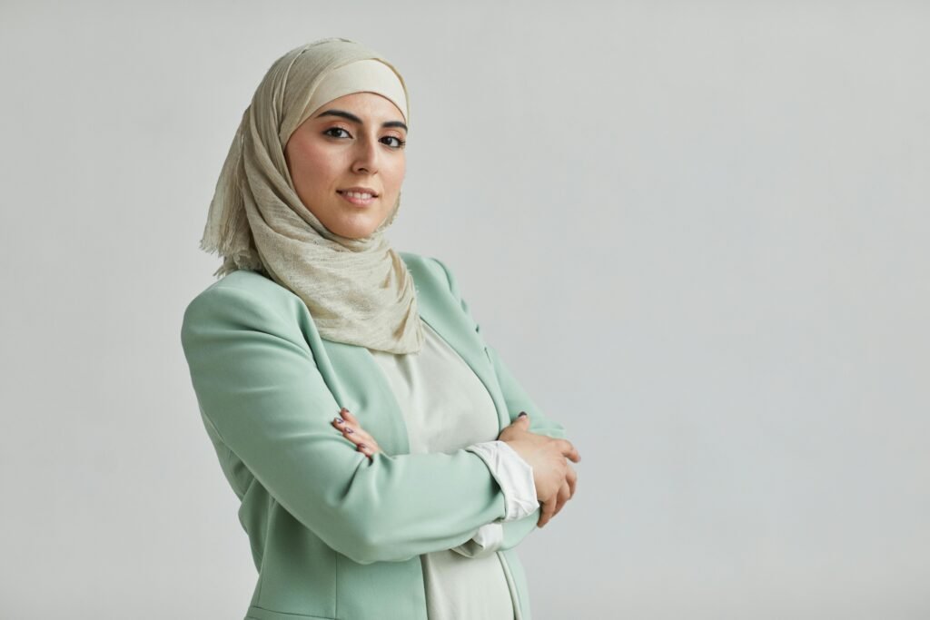 foto de mulher branca usando hijab terno social azul claro bracos cruzados