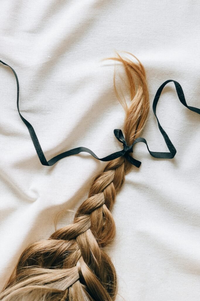 foto de um cabelo longo com trancas e um fita amarrada no final