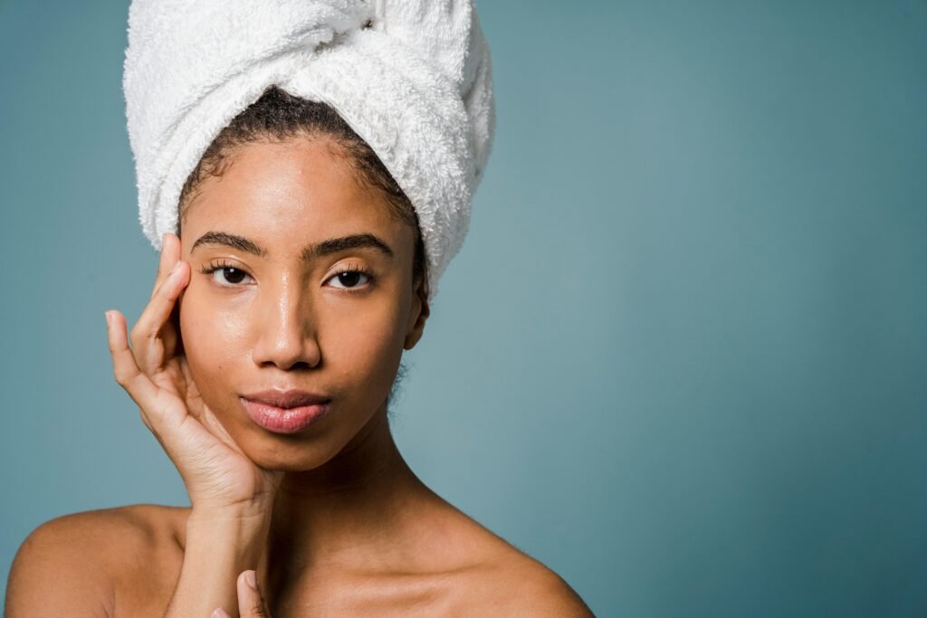 foto de perfil de mulher morena toalha na cabeça mão no rosto