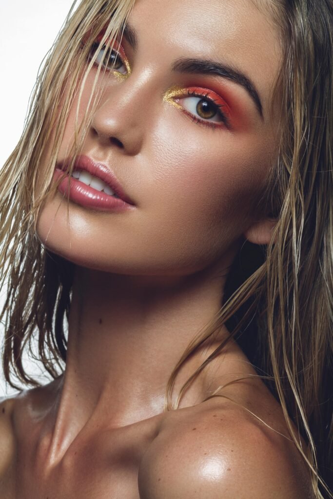 foto de perfil de mulher loira cabelos molhados maquiada olhos castanhos claros maquiagem no olhos