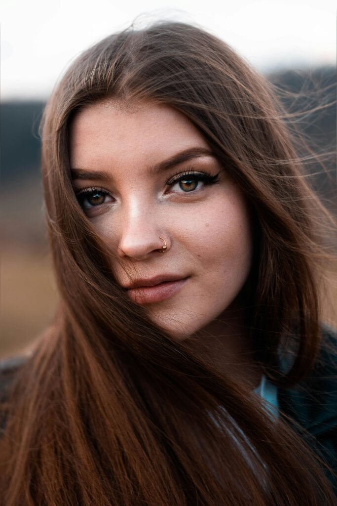 foto de perfil de mulher morena cabelos lisos longos soltos olhos castanhos esverdeados piercing no nariz