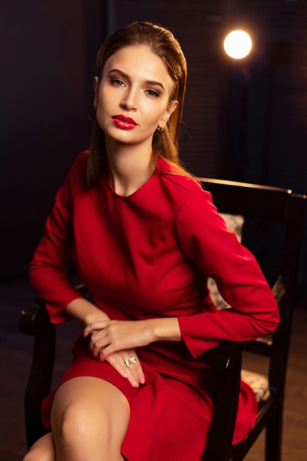 mulher maquiada cabelos lisos longos presos vestido vermelho social batom vermelho foto de Andrey Zvyagintsev unsplash.com