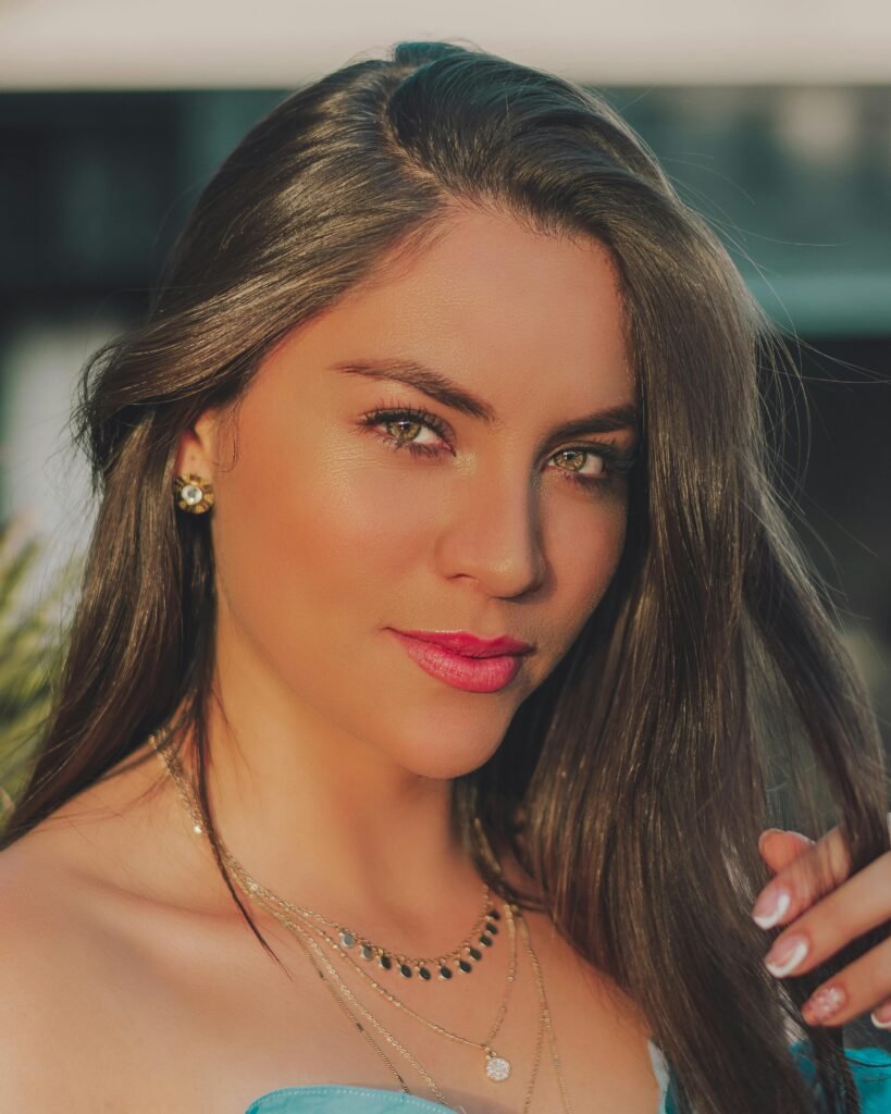 foto de mulher morena maquiada brincos pequenos cabelos longos lisos soltos olhos verdes com pequenos colares