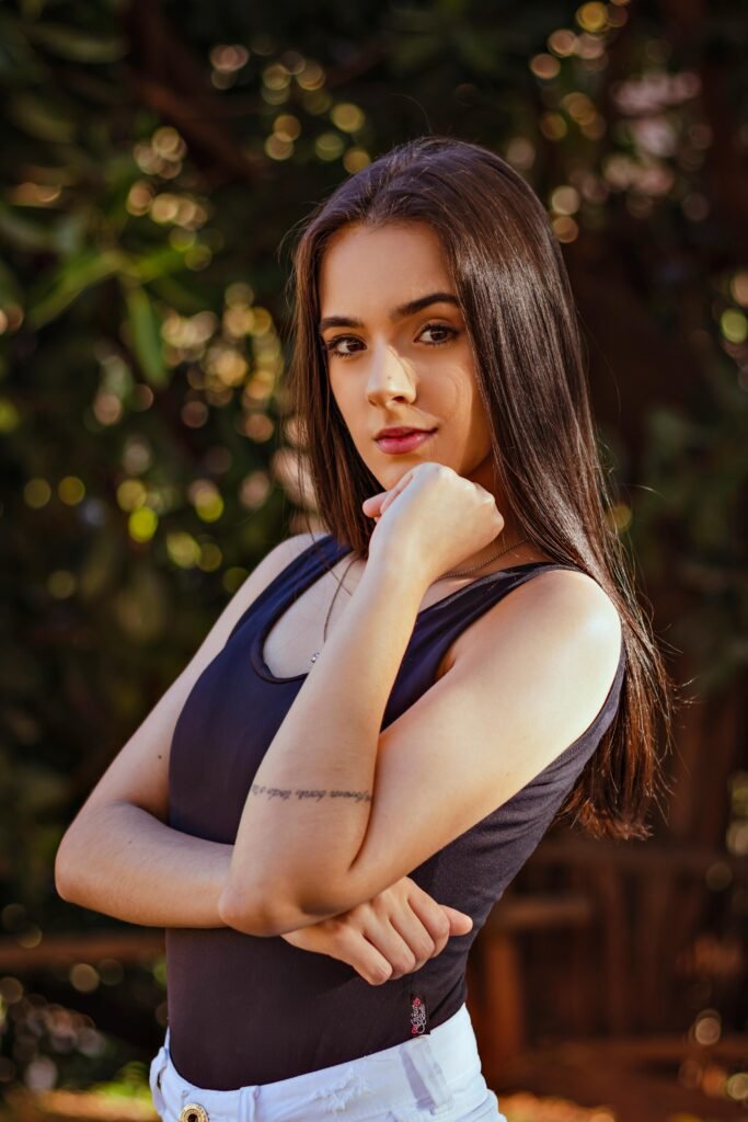 foto de mulher morena cabelos pretos lisos longos olhos castanhos leve maquiagem uma das mãos no queixo