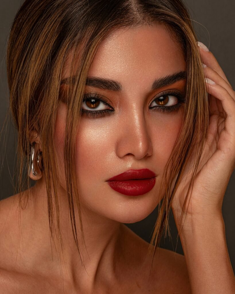 mulher maquiada batom vermelho olhos castanhos cabelos penteados lisos presos brinco grande prata 
