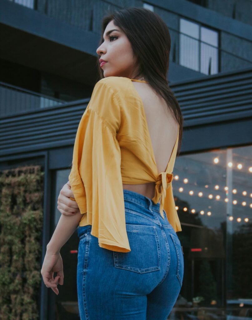 mulher de costas com blusinha retro com laco nas costas cor amarela calca jeans guia completo sobre retro blouses e blusinhas retro tudo o que você precisa saber para arrasar no estilo vintage