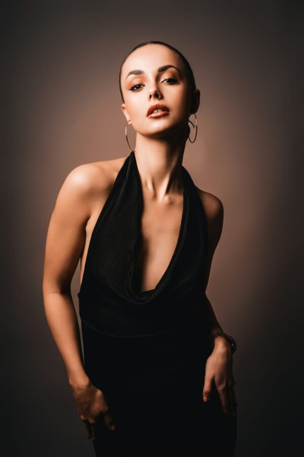 mulher com cabelo preso penteado em gel brincos argolas grandes vestido elegante preto foto de Jay Soundo unsplash.com