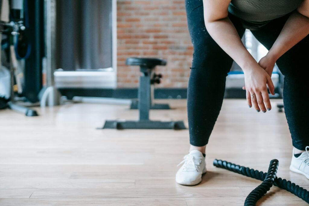 foto de parte de uma mulher agachada para fazer exercício com corda em academia