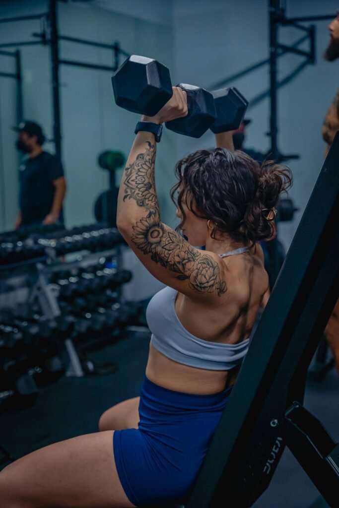 foto de mulher branca com tatuagem no braco roupa de academia fazendo exercício pra perder peso