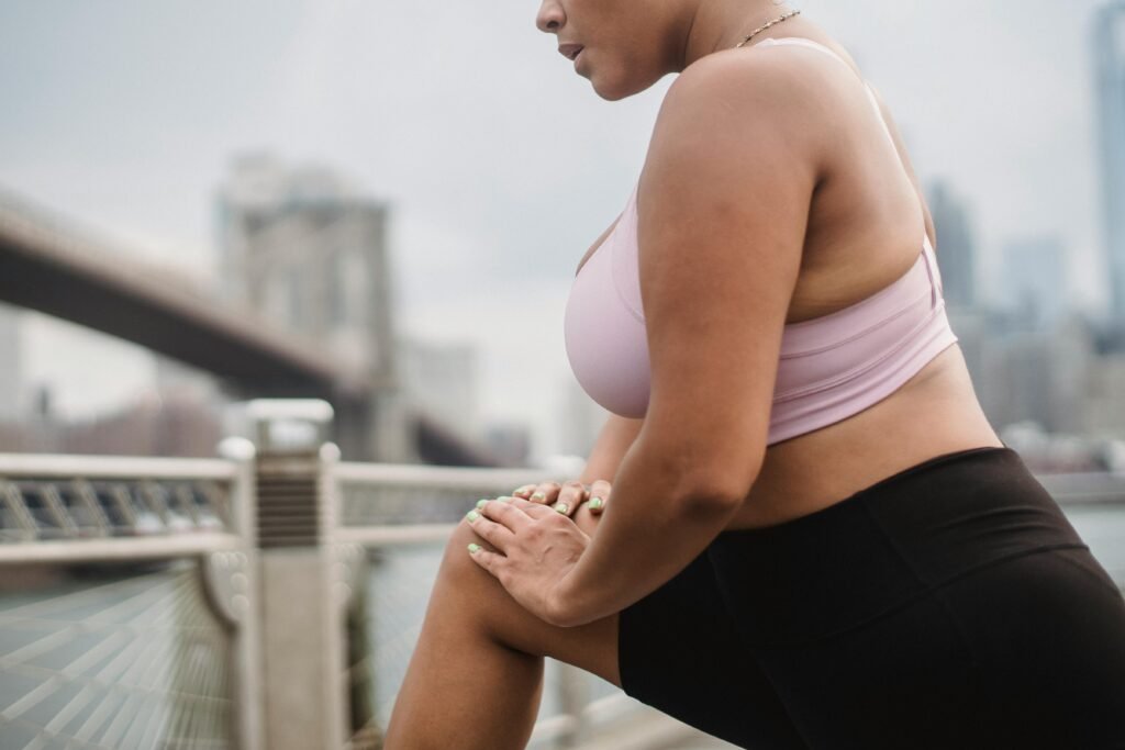 mulher com roupa de academia unhas verdes fazendo exercício para perder peso