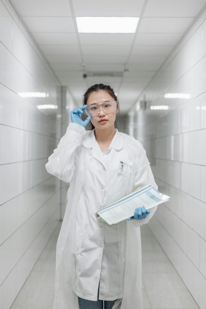 foto de uma mulher oriental com jaleco branco medica segurando papeis