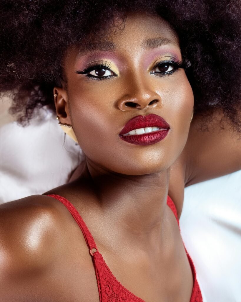 mulher preta linda maquiada batom vermelho brincos estilosos cabelos crespos grandes olhos castanhos escuros