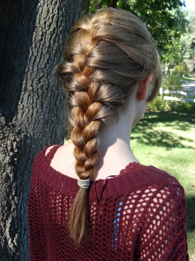 foto de mulher que esta de costas com tranca francesa em seu cabelo liso longo loiro
