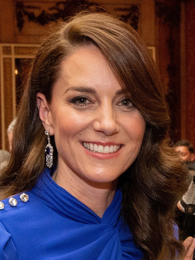 Princesa Kate Middleton sorrindo cabelos lisos longos soltos vestido azul foto de Ian Jones