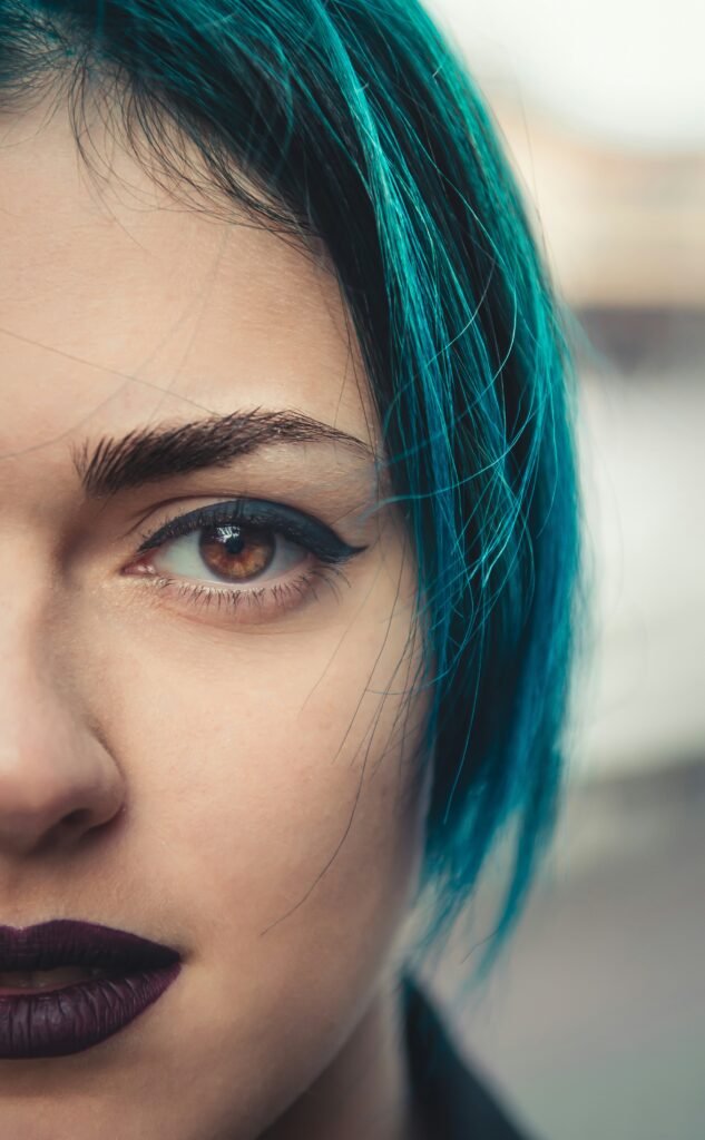 mulher cabelo liso curto azul batom roxo olhos castalhos claros