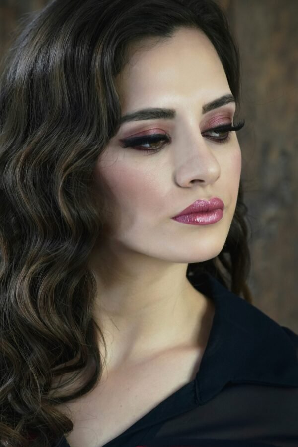 mulher maquiada seria batom roxo cabelos pretos ondulados soltos blusinha preta foto de DIEGO SÁNCHEZ unsplash.com