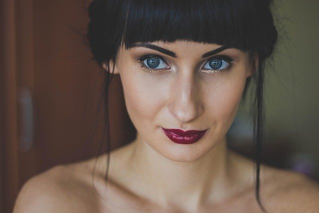mulher maquiada olhos zauis batom roxo brilhante cabelos pretos lisos corte franja