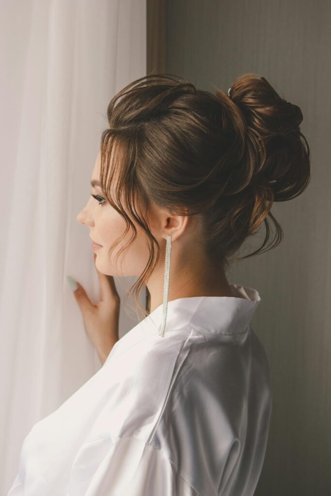 foto de lado de mulher morena cabelos presos coque french hair pin brinco comprido leve maquiagem