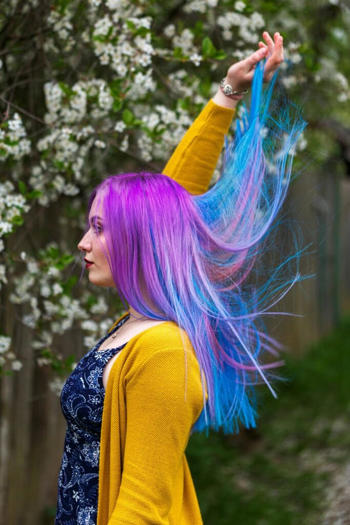 mulher maquiada de lado cabelos lisos longos colorido de violeta e azul vestido preto e blusinha amarela HopeScope: a rainha dos testes divertidos