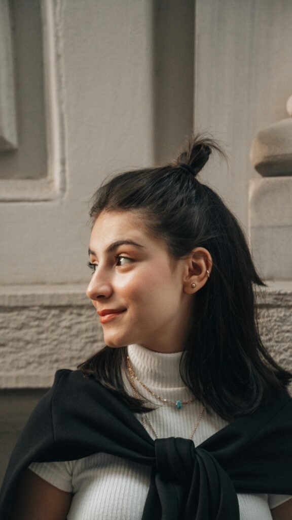 mulher branca cabelos pretos Layered shoulder length hair. Cabelo em camadas na altura dos ombros leve maquiagem e sorriso brincos pequenos na orelha