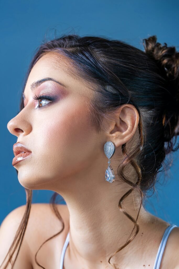 mulher maquiada cabelos pretos presos com penteado brincos grandes prata