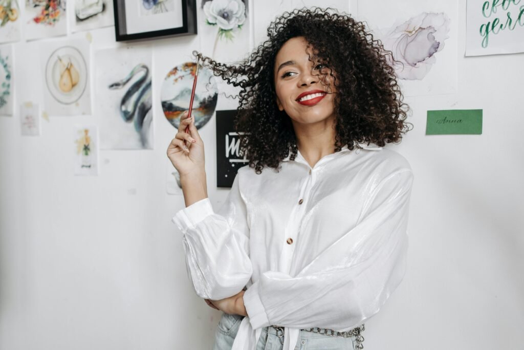 foto de mulher morena sorrindo cabelos cacheados 3c leve maquiagem camisa social branca