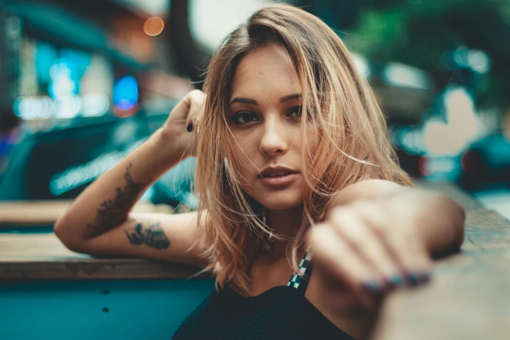 mulher jovem loira braco tatuado Layered shoulder length hair. Cabelo em camadas na altura dos ombros