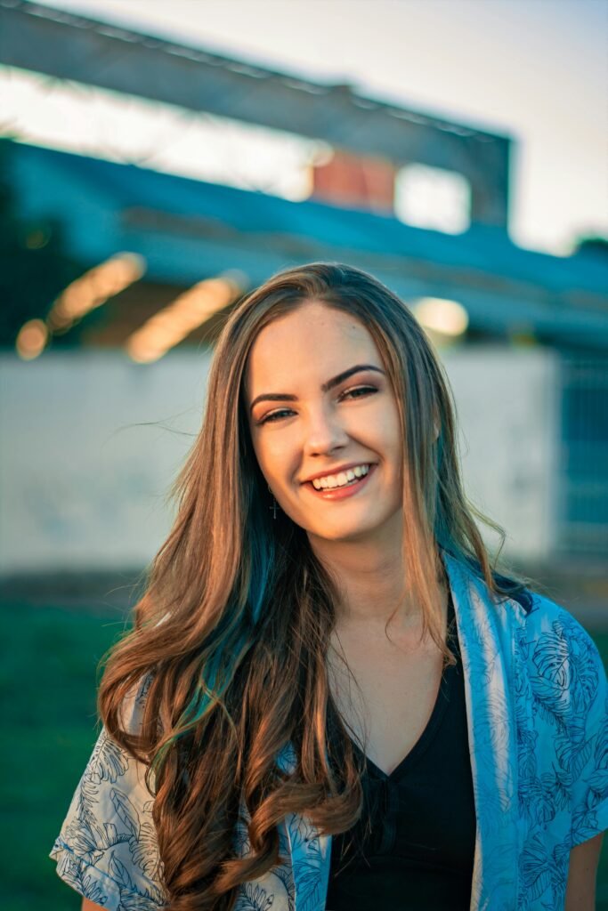 mulher sorrindo cabelos lisos longos soltos blusinha preta e camisa social estampada branca
