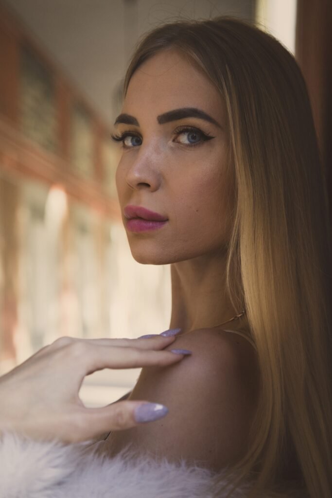 mulher loira cabelos lisos longos batom roxo unhas roxa