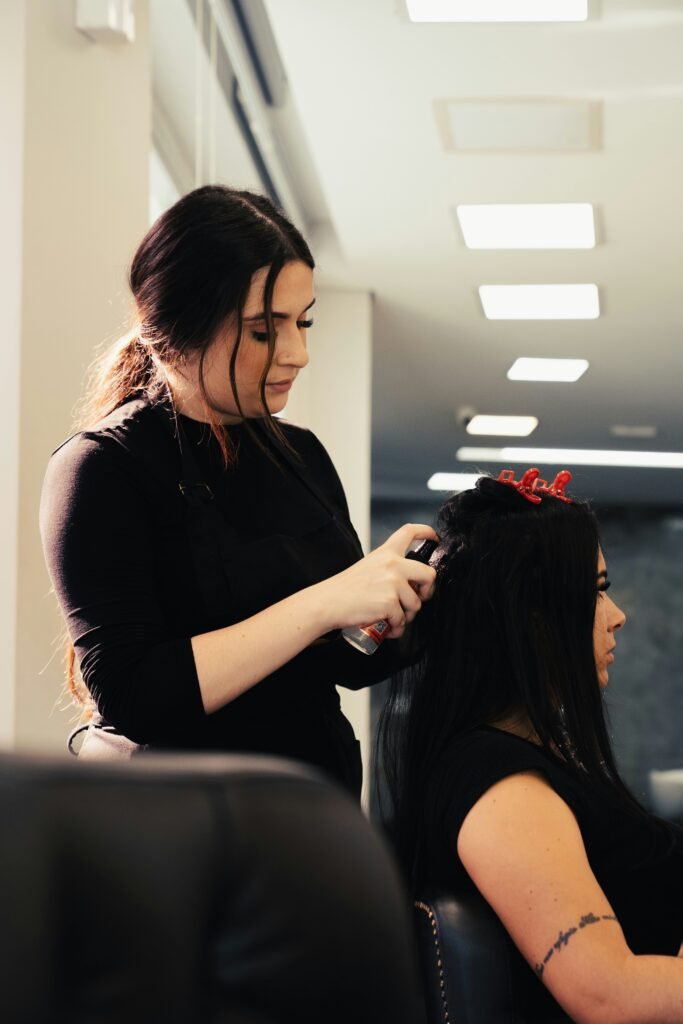 mulher no salão de beleza arrumando seus cabelos pretos lisos longos soltos passando óleo para hidratar make my hair beautiful deixar meu cabelo lindo