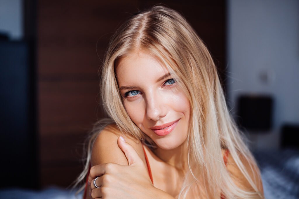 mulher loira sorrindo olhos azuis cabelos lisos longos 