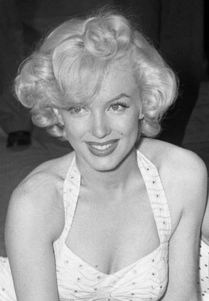 Marilyn Monroe sorrindo foto em branco e preto vestido estiloso com alca no pescoço ruby red lipstick and Marilyn Monroe the symbol of femininity and glamour