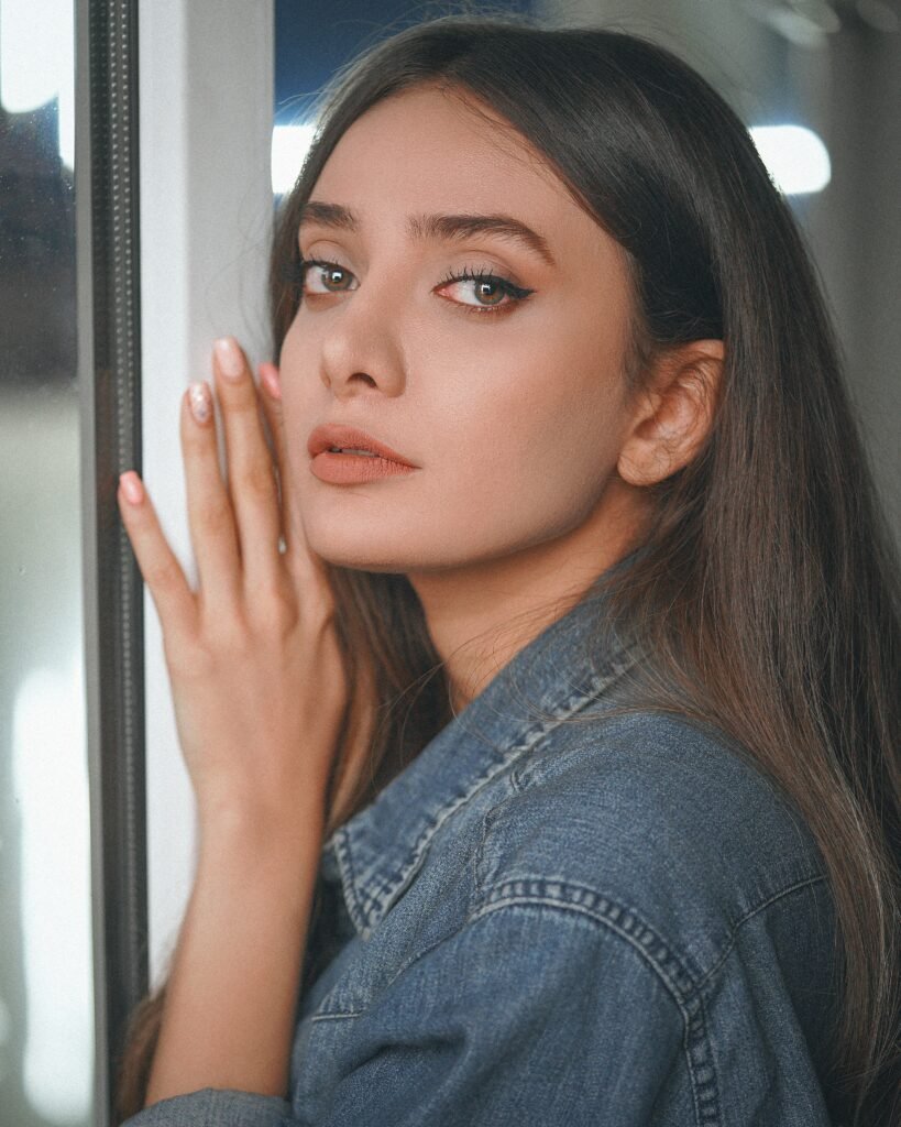 mulher maquiada olhos castanhos cabelos lisos longos pretos jaqueta jeans azul