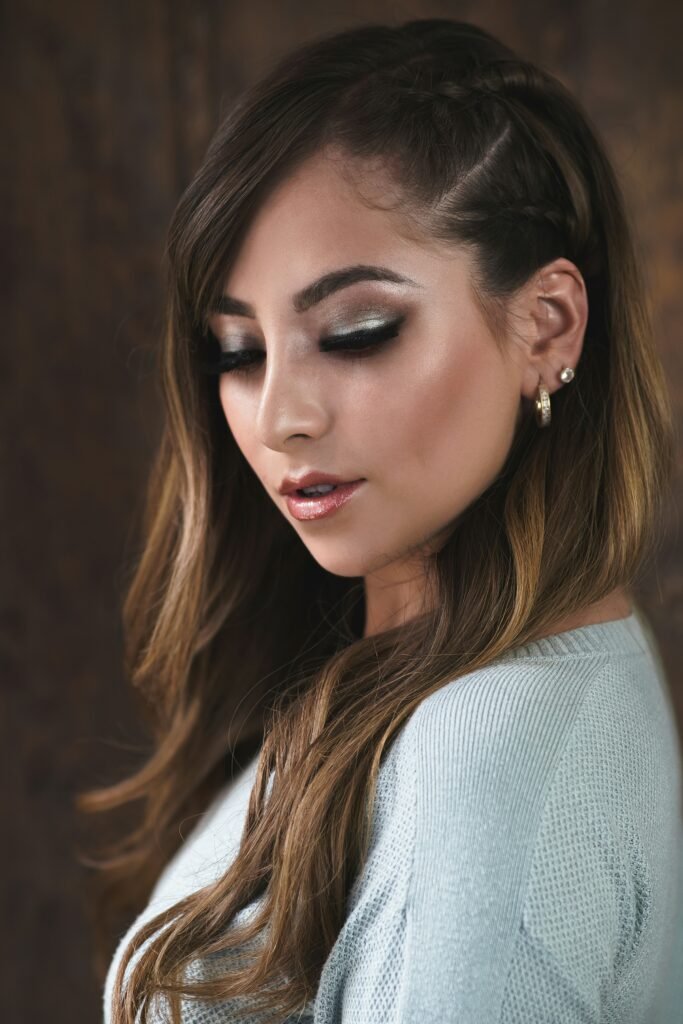 mulher maquiada olhos esfumados batom brilhoso dois brincos pequenos cabelos lisos longos castanhos blusinha cinza o poder da maquiagem learn to do makeup e aprenda maquiagem