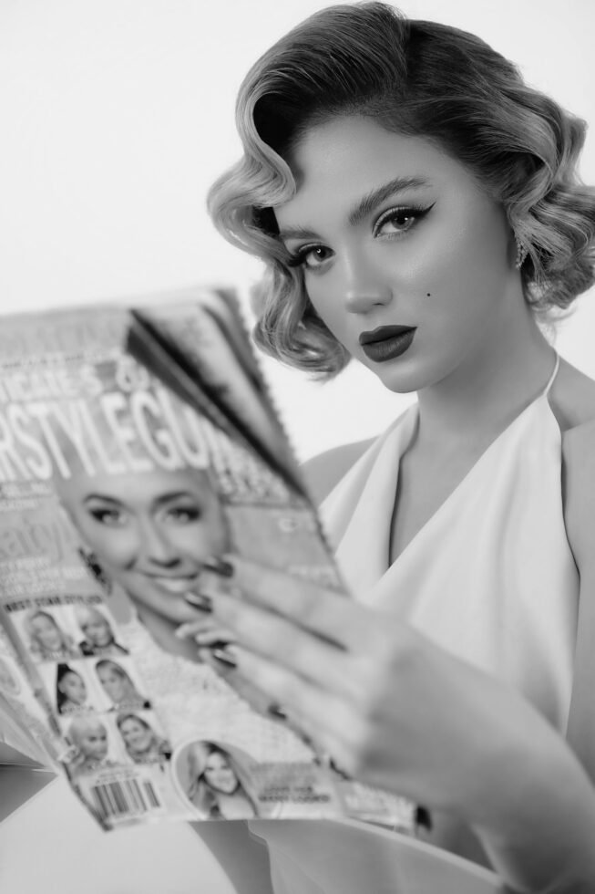 mulher maquiada estilo marylin monroe segurando uma revista de moda foto de Kimia Zarifi unsplash.com