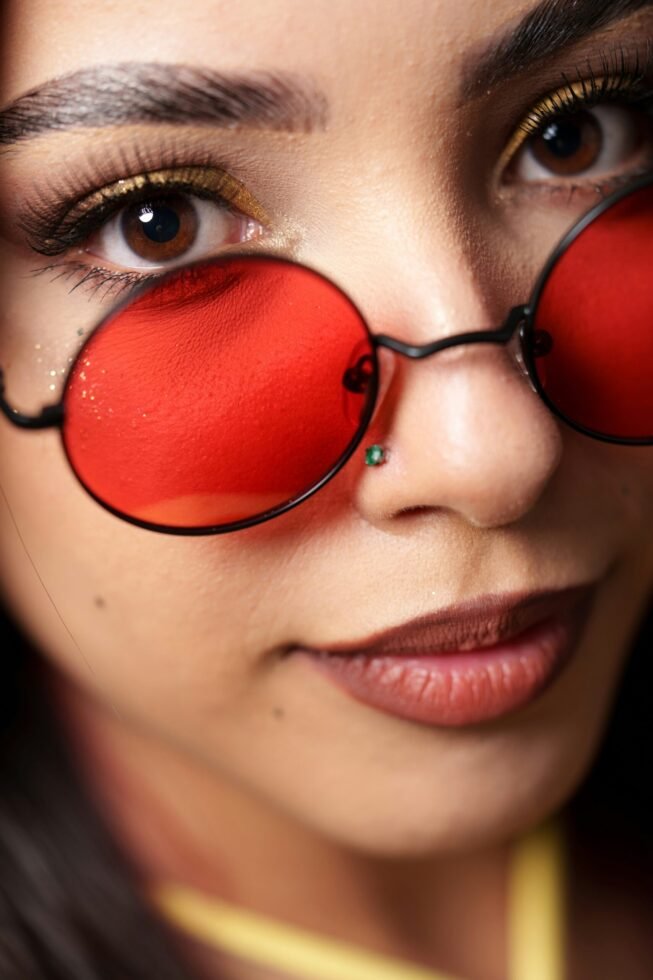 mulher maquiada olhos castanhos oculos estiloso redondo lente vermelha foto de Naveen Raj Dhanapal unsplash.com