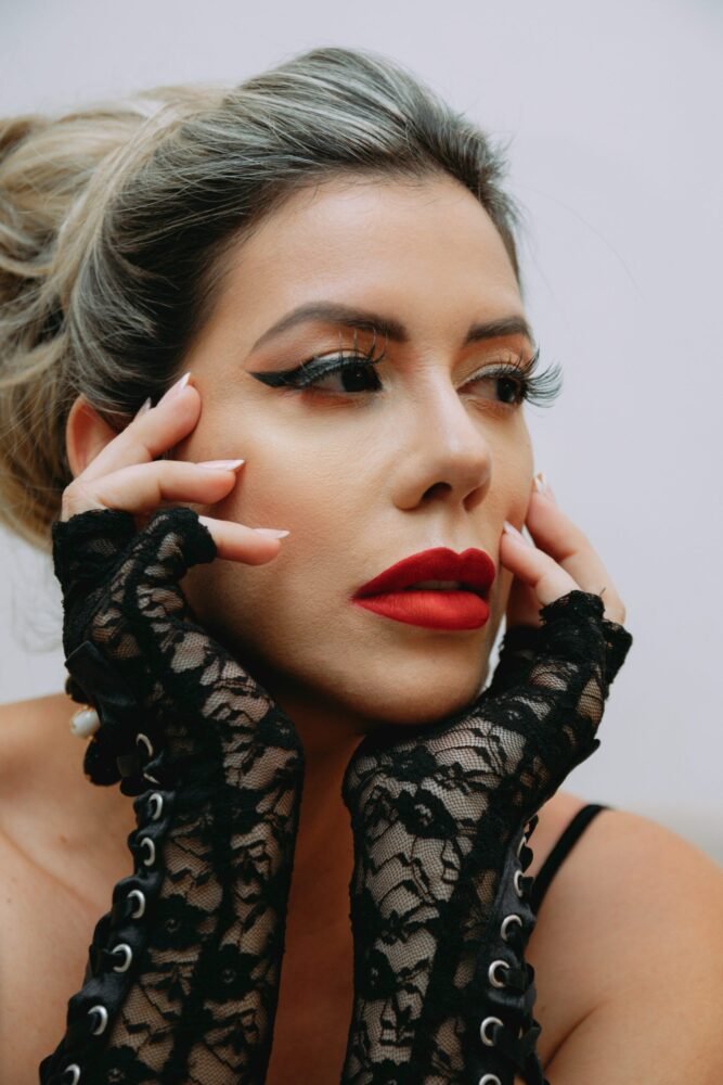 mulher maquiada batom vermelho olhos de gatinha duas maos no rosto foto de Soy Breno unsplash.com